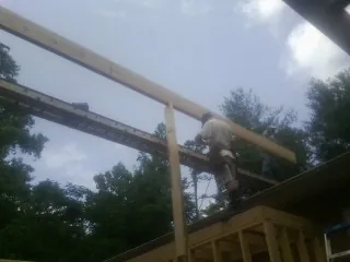 Carpenter setting a ridge beam over a new addition frame — Ice Dam Removal by Roofing Brothers in Vass