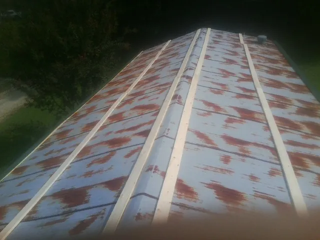 Rusted metal roof panels with new wood purlins before replacement — Storm Damage Roof Repair in Vass by Roofing Brothers
